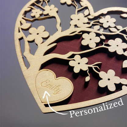 Close-Up of Wooden Heart with cherry blossom cutouts. arrow pointing to customized name.